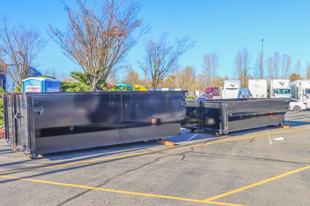 Professional dumpster rental service with roll-off container on residential driveway in Forest City